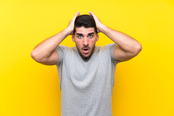 Young handsome man over isolated yellow background with surprise facial expression
