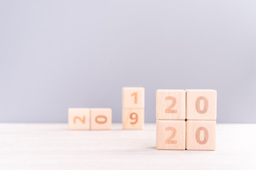 Abstract 2020, 2019 New year target plan design concept - wood blocks cubes on wooden table and pastel blue background, close up, blank copy space.