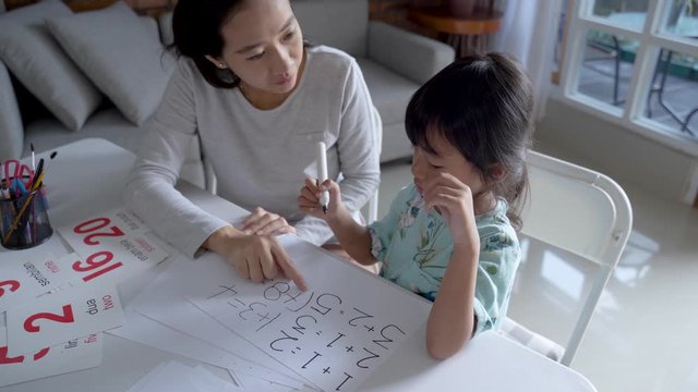 mother teaching basic math to her little daughter at home