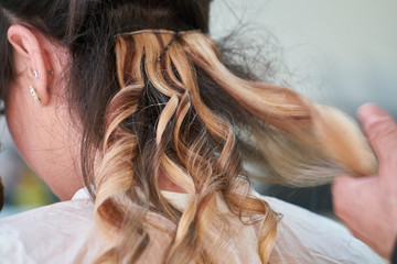 Naklejka premium Woman hairdresser making hairstyle in beauty salon