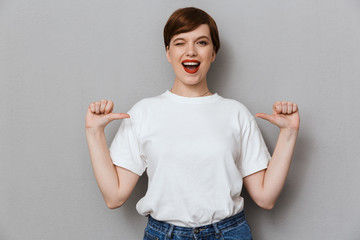 Image of winking brunette woman smiling and pointing fingers at herself