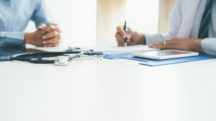 Patient listening intently to a male doctor explaining patient symptoms or asking a question as...