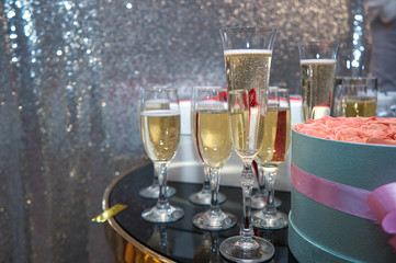 a holiday poured into glasses of champagne, next to it is a bouquet of flowers