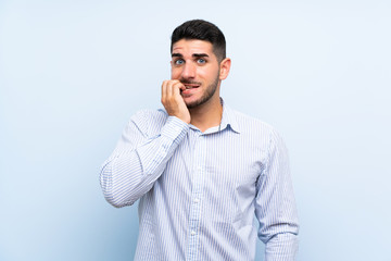 Fototapeta premium Caucasian handsome man over isolated blue background nervous and scared