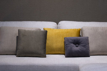Modern brown, yellow and gray fabric flannel pillows on gray fabric cushion sofa interior decoration