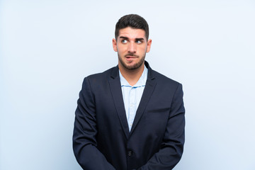 Handsome man over isolated blue background with confuse face expression