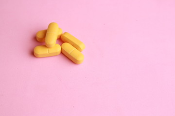 orange elongated pharmacy pills on colored background