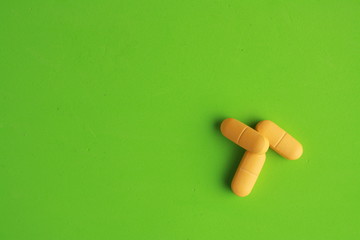 orange elongated pharmacy pills on colored background