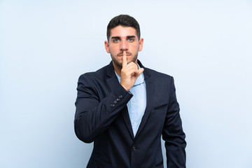 Handsome man over isolated blue background showing a sign of silence gesture putting finger in mouth