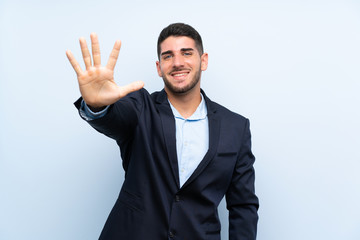 Handsome man over isolated blue background counting five with fingers