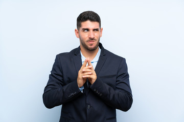 Handsome man over isolated blue background scheming something