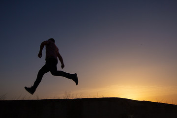 Fototapeta na wymiar silhouette of man running at sunrise