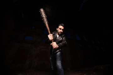 man in leather jacket and baseball bat