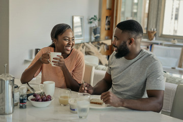 Fototapeta na wymiar Young African American couple laughing together over breakfast