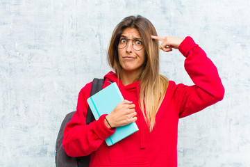 young pretty student with a serious and concentrated look, brainstorming and thinking about a...
