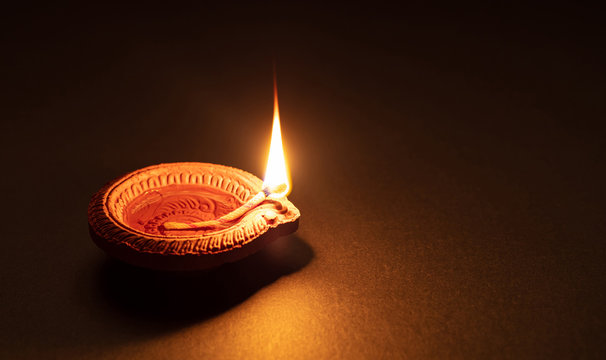 Diwali, Hindu festival of lights celebration. Diya oil lamp against dark background,