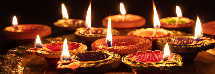Diwali, Hindu festival of lights celebration. Diya oil lamps against dark background,