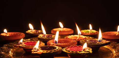 Diwali, Hindu festival of lights celebration. Diya oil lamps against dark background,