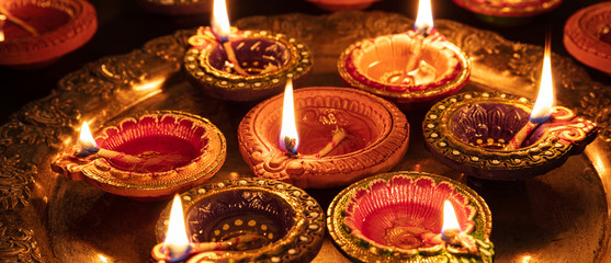 Diwali, Hindu festival of lights celebration. Diya oil lamps against dark background,