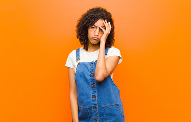 young pretty black woman feeling bored, frustrated and sleepy after a tiresome, dull and tedious...