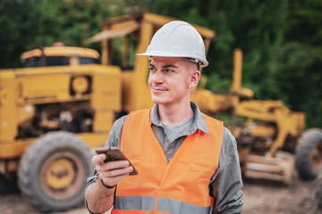 Portrait of caucasian engineers use smartphones in the workplace. Road construction site
