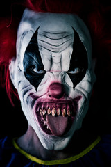 scary evil clown sticking out his tongue