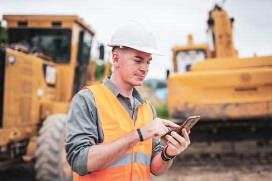 Portrait of caucasian engineers use smartphones in the workplace. Road construction site