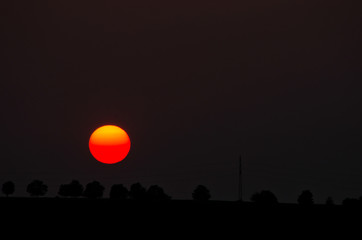 Orange sunset on horizon with big orange sun