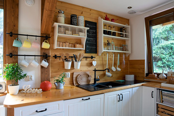 Interior of kitchen in rustic style with vintage kitchen ware and window. White furniture and...