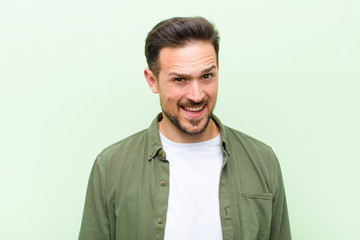 young handsome man with a big, friendly, carefree smile, looking positive, relaxed and happy,...