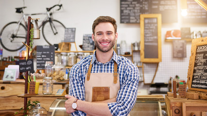 Smiling young barista standing in a trendy cafe