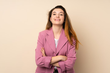 Young brunette girl with blazer over isolated background keeping the arms crossed in frontal position