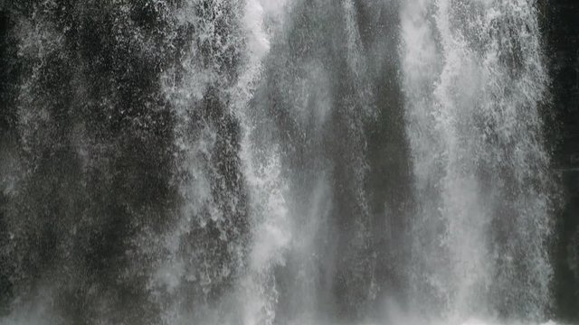 Close up slow motion of waterfall water falling down to the cliff nature background footage
