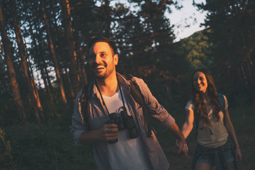 Happy couple is hiking in forest.