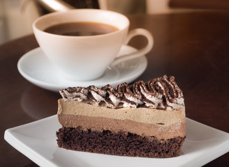 Slice of Tiramisu coffee cake on a white plate. Chose up of coffee chocolate layer cake.