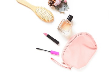 Flat lay photography beauty products and cosmetic bag. Hair brush, pink lipstick, mascara, perfume...