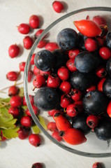 forest fruit in a glass bowl on a wooden table as decoration