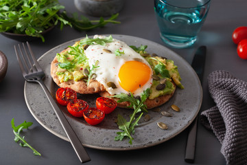 breakfast avocado sandwich with fried egg and tomato