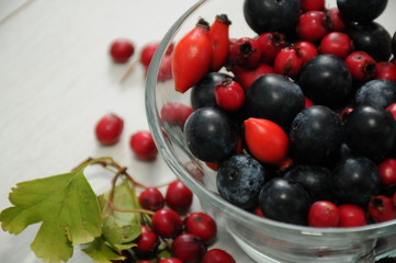 forest fruit in a glass bowl on a wooden table as decoration