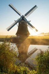 Fotobehang Windmill during a foggy sunrise in the Dutch countryside. Krimstermolen, Zuidwolde. © sanderstock