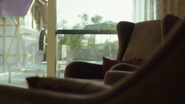 armchairs in a comfortable lounge with big sliding doors leading into a green garden - Sessel in einer gem&uuml;tlichen lounge mit gro&szlig;en Schiebet&uuml;ren die in einen gr&uuml;nen Garten f&uuml;hren
