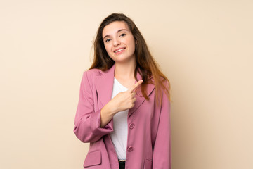 Fototapeta premium Young brunette girl with blazer over isolated background pointing to the side to present a product
