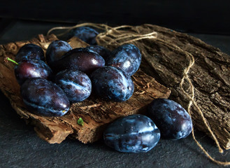 Garden plums on the table. Autumn harvest. Blue plums. Fresh plums on a wooden surface. Fresh plums on a wooden table background. Food Photo