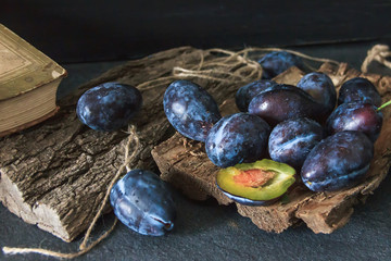 Garden plums on the table. Autumn harvest. Blue plums. Fresh plums on a wooden surface. Fresh plums on a wooden table background. Food Photo