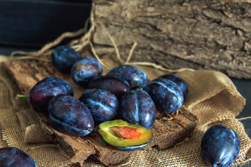 Garden plums on the table. Autumn harvest. Blue plums. Fresh plums on a wooden surface. Fresh plums on a wooden table background. Food Photo