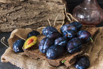Garden plums on the table. Autumn harvest. Blue plums. Fresh plums on a wooden surface. Fresh plums on a wooden table background. Food Photo