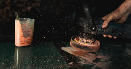 Mechanic's hands using professional glass polishing tool to remove scratches