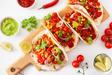 mexican beef and pork tacos with salsa, guacamole and vegetables