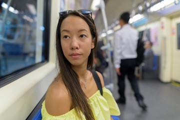 Young tourist woman exploring the city of Bangkok with metro train