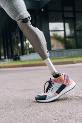 partial view of disabled sportswoman with prosthesis on street